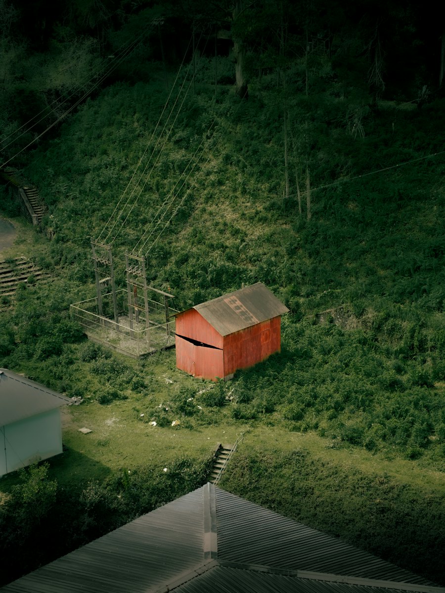 Small red storage shed in a green yard